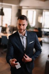 Businessman giving visit card. Handsome businessman in office 