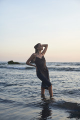   Female lifestyle model at the black sand beach at dask time    