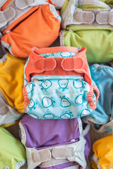 set of colored cloth diapers with fun designs, top-view vertical