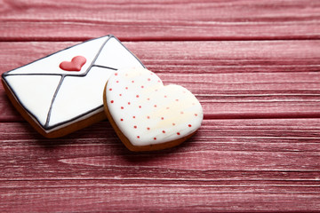 Valentine day heart and envelope shaped cookies on red wooden table