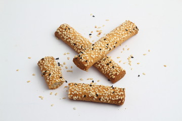 Bread sticks with mix of seeds on white background