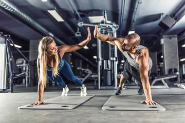  Sportpaar die de training van de plankoefening in geschiktheidscentrum doen. Man en vrouw oefenen plank in de sportschool © weyo
