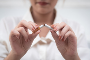 woman breaking cigarette to quit smoking; smoking ban or no smoking concept - obrazy, fototapety, plakaty