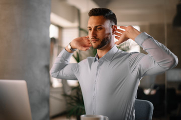 Portrait of handsome businessman in office. Tired businessman working on laptop in office	.