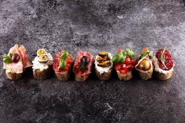Appetizers table with italian antipasti snacks and wine in glasses. Brushetta or authentic traditional spanish tapas set, cheese variety