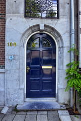 Fototapeta na wymiar Amsterdam, Holland, August 2019. Along the river Amstel, on the outskirts of the city it is easy to meet house doors with a strong appeal to the London style.