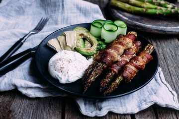 Baked asparagus in bacon with egg, avocado and cheese