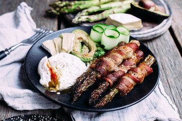 Baked asparagus in bacon with egg, avocado and cheese
