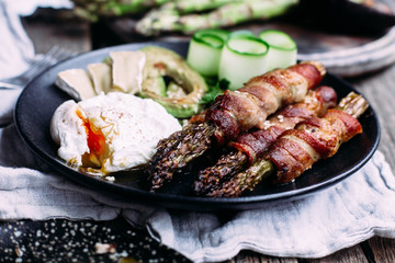 Baked asparagus in bacon with egg, avocado and cheese