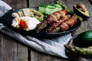 Baked asparagus in bacon with egg, avocado and cheese