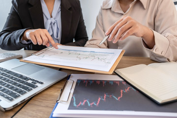 Businesswoman investor on meeting having planning and analyzing of partner cooperation in investment trading marketing project and pointing on the data presented and deal a stock exchange to profit