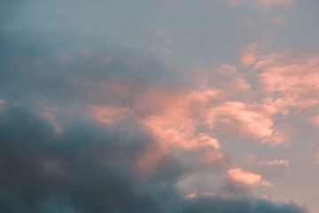 clouds with a pink tinge of sunset in a blue sky