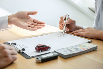 Naklejka premium Car rental and Insurance concept, Young salesman presenting and pointing signature form to customer signing after decision sign agreement contract with approved good deal for rent or purchase