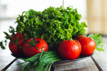 Fresh bright vegetables and herbs on a wooden table.