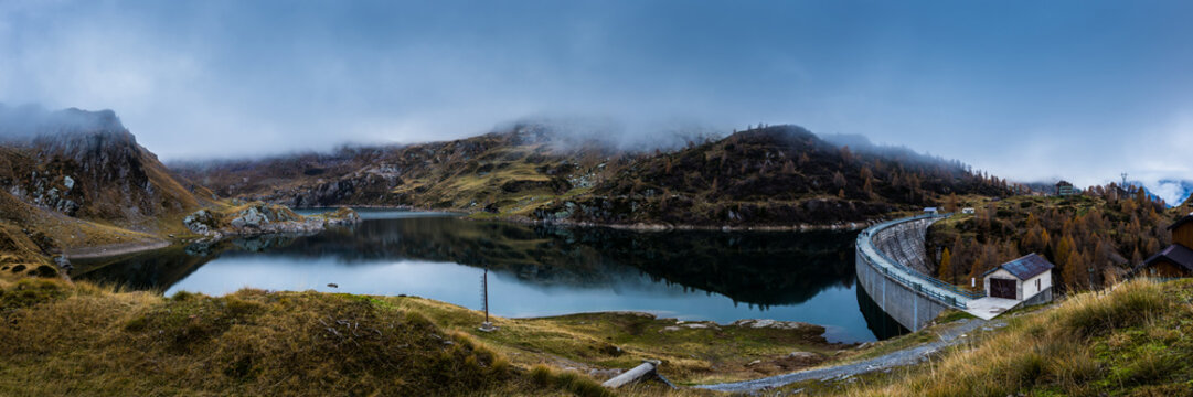 panoramic view of a dam lake in mountain in a cludy day