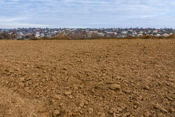 Plowed field at autumn. City Uman on a background. Ukraine