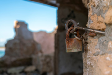Rusty padlock with unfocused background. In a ruined shed in the cove of Ses Covetes, Majorca