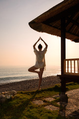 A young girl practices yoga on the ocean. Yoga. Bali