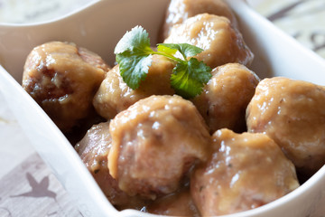 Homemade pork meat dumplings in onion sauce over white bowl
