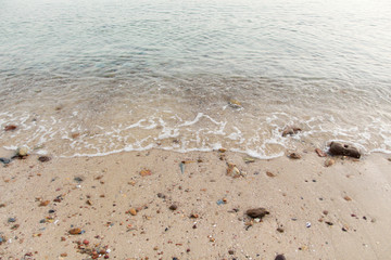 An empty sandy beach with a wavy background