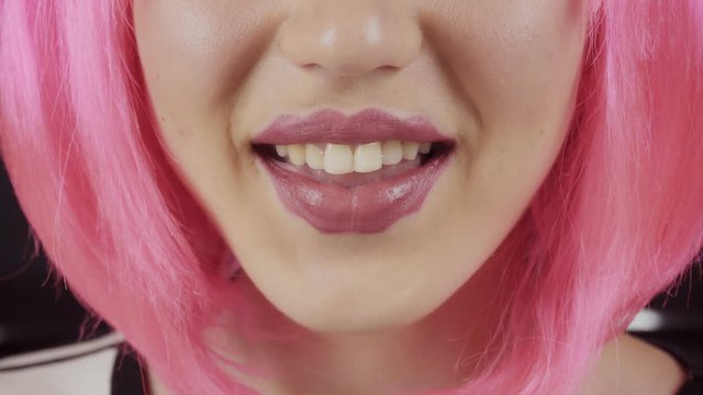 Girl with the lips of the devil. Young beautiful girl with pink hair. A new trend in cosmetology