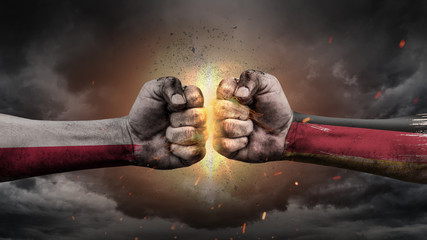 Poland vs Germany. Fists with flags. Battle of two countries on sky.	
