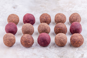 Homemade Raw Vegan Cacao Energy Balls Lie in Row on White Marble Background. Healthy Chocolate Candy from Nuts and Dates. Concept of Natural Vegetarian Handmade Dessert