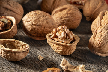 Whole and broken walnuts on a wooden table