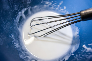 Kekse und Plätzchen backen in einer Bäckerei, Handwerk, Schneebesen mit Zuckerguß in einer...