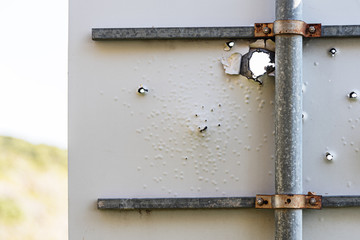 Road sign with bullet holes.
