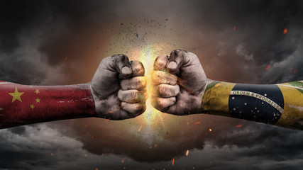 China vs Brasil. Fists with flags. Battle of two countries on sky.	