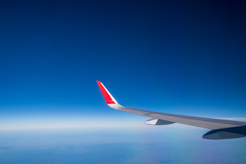 Flying on an airplane wing on a blue sky