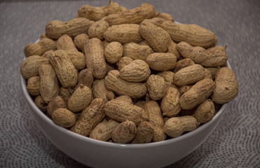 peanuts in bowl on wooden table