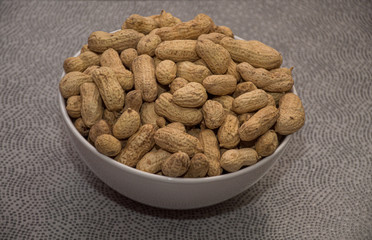 peanuts in bowl on wooden table