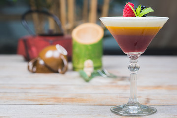Tiramisu traditional dessert in a glass goblet on a wooden table.