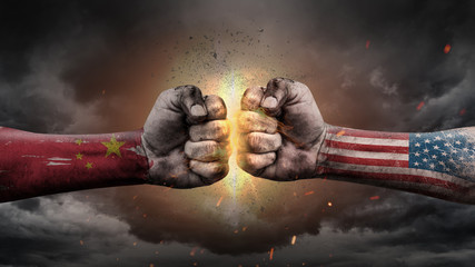 China vs USA. Fists with flags. Battle of two countries on sky.