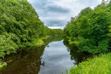 Summer view of a river in Sweden with lush green foliage along the riverside