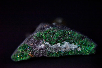 Emerald crystals on the dark background with the side light.