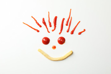 Handmade smiley face with tasty french and red sauce fries isolated on white background, top view