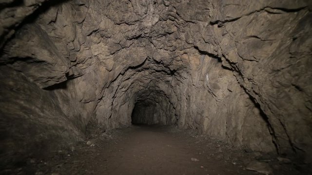 Speleology artificial cave dark tunnel excavation underground. Old adit for the extraction of metal and rocks