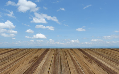 Perspective wooden board empty table top over  blue sky with cloudy . Can be used for montage or display your products.
