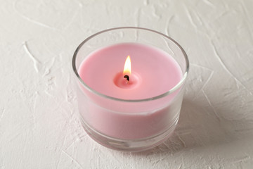 Fototapeta na wymiar Pink candle in glass jar on white background, close up