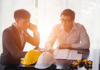 Businessmen and colleagues are interacting with smartphones in the office, while engineers are checking their blueprints.