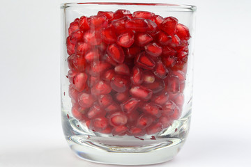 Red Pomegranate seed in glass on white background