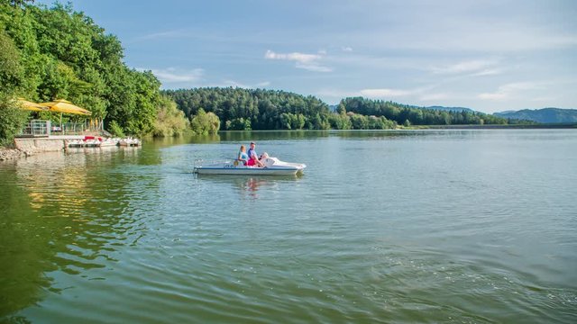 Couple paddle on idyllic lake Smartinsko, Slovenia. Handheld