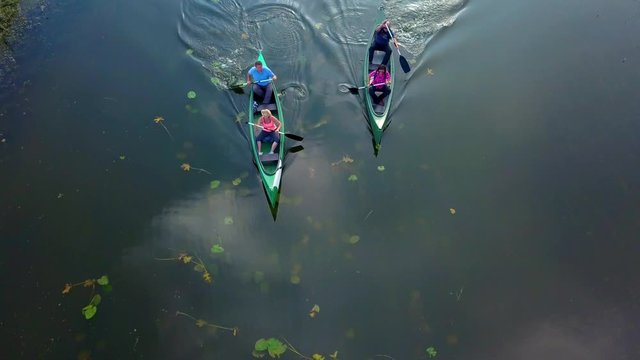 Tracking reveal shot of people on kayak on river Cerknica, Slovenia. Aerial