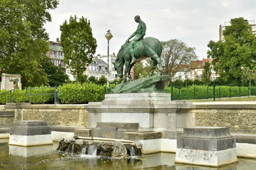 Fototapeta na wymiar Cavalier en bronze sur socle en marbre à l'une des pièces d'eau du square Ambiorix à Bruxelles