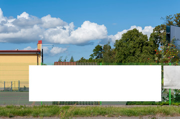 Advertising banner mockup on the fence of factory/warehouse building