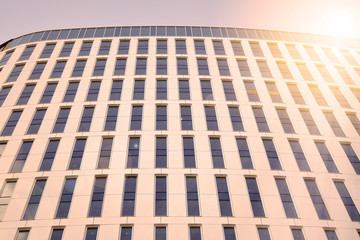 Sun rays light effects on urban buildings. Modern office building detail, glass surface with sunlight. Business background. 