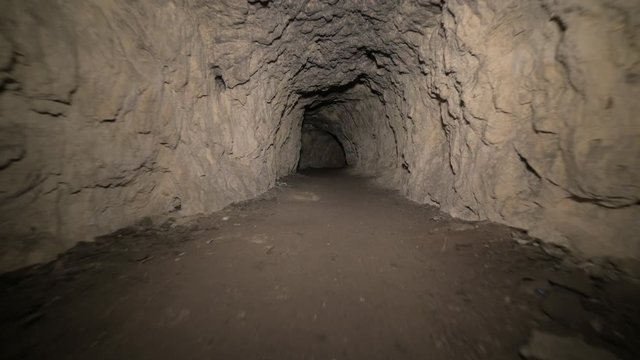 Speleology artificial cave dark tunnel excavation underground. Old adit for the extraction of metal and rocks